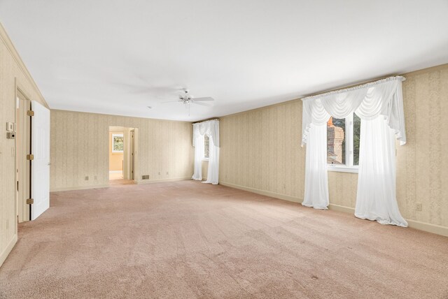 spare room featuring a healthy amount of sunlight, ceiling fan, and light carpet