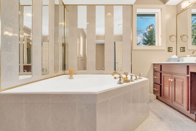 bathroom featuring a relaxing tiled tub, tile patterned floors, and vanity