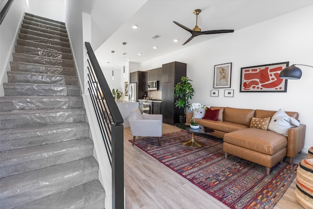 living room featuring ceiling fan and light hardwood / wood-style flooring