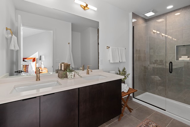 bathroom with tile patterned flooring, vanity, and a shower with door