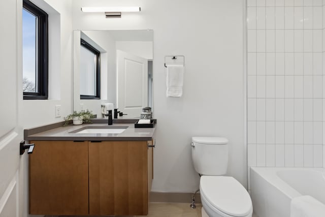 full bathroom with tiled shower / bath, vanity, and toilet