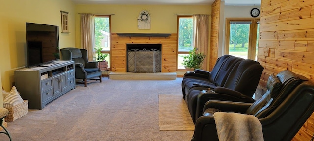 living room featuring a wealth of natural light, wooden walls, and light carpet