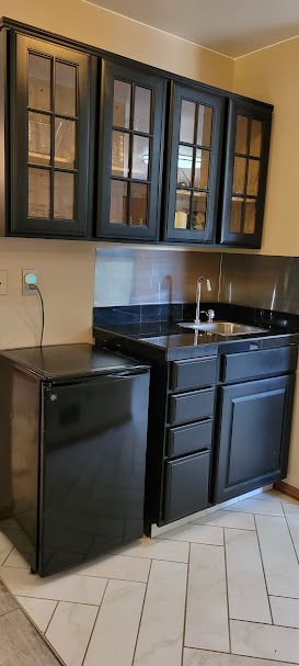 bar featuring light tile patterned floors and sink