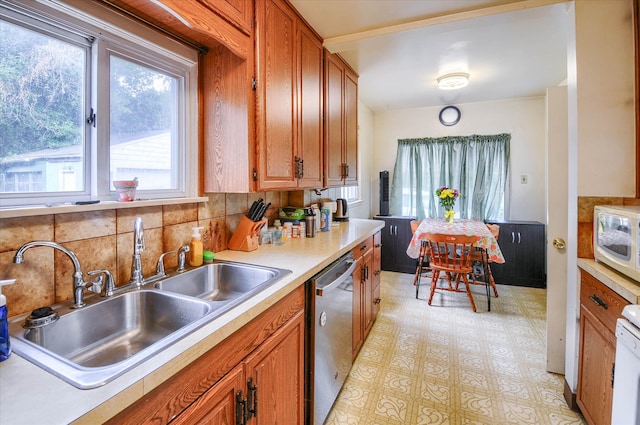 kitchen featuring tasteful backsplash, stainless steel dishwasher, and sink