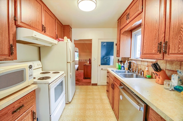 kitchen featuring backsplash, white appliances, and sink