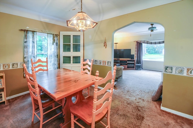 dining space featuring carpet flooring and ceiling fan with notable chandelier