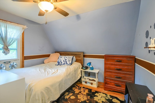 bedroom with ceiling fan, wood-type flooring, and vaulted ceiling