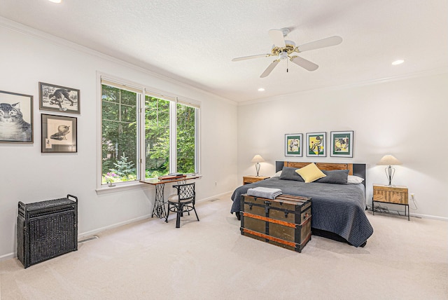 bedroom with ceiling fan, a textured ceiling, light carpet, and crown molding