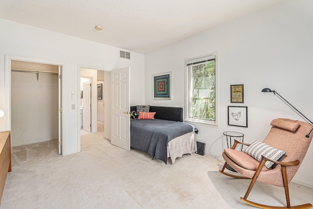 bedroom featuring light carpet, a closet, and a spacious closet