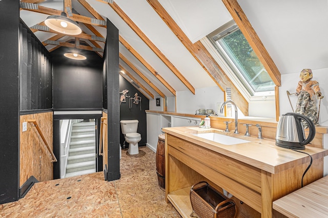 bathroom with vanity, toilet, and lofted ceiling with skylight