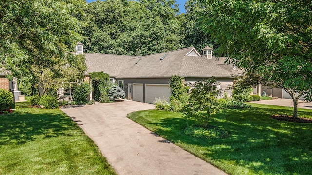 view of front of home with a garage and a front lawn