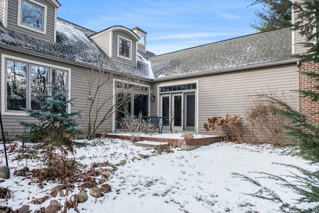 view of snow covered back of property