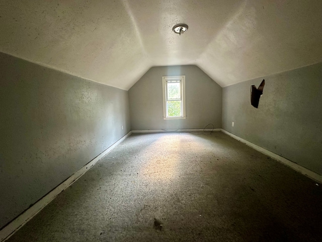 bonus room with a textured ceiling and lofted ceiling