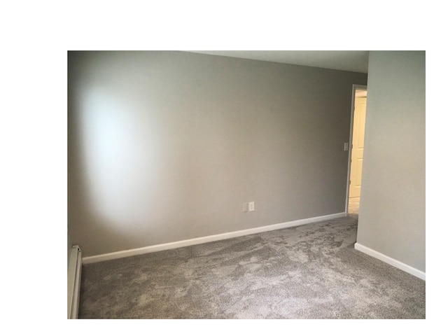 empty room with carpet and baseboard heating