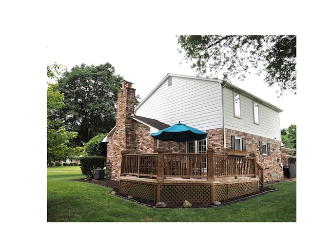 rear view of house featuring a lawn, cooling unit, and a deck