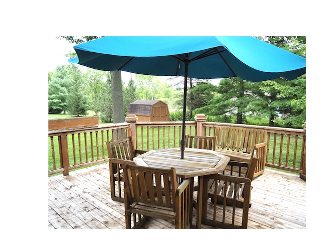 wooden terrace featuring a yard and a storage shed