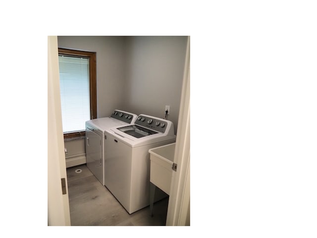 laundry room featuring washing machine and dryer and light hardwood / wood-style floors