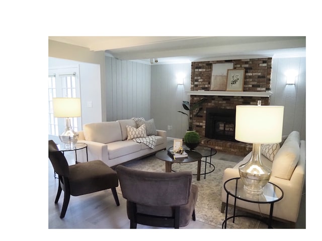 living room featuring a fireplace, hardwood / wood-style floors, crown molding, and wood walls