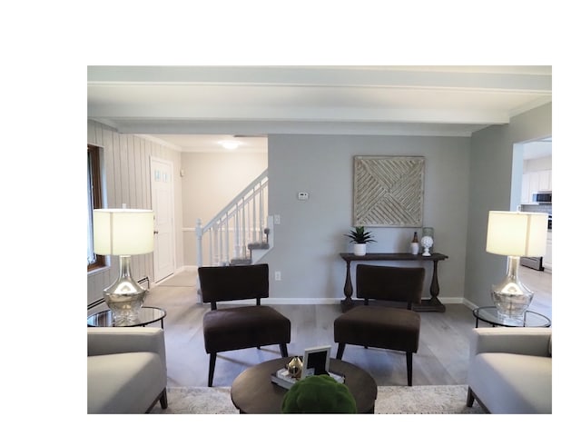 living room with wood walls, beam ceiling, crown molding, and light hardwood / wood-style flooring