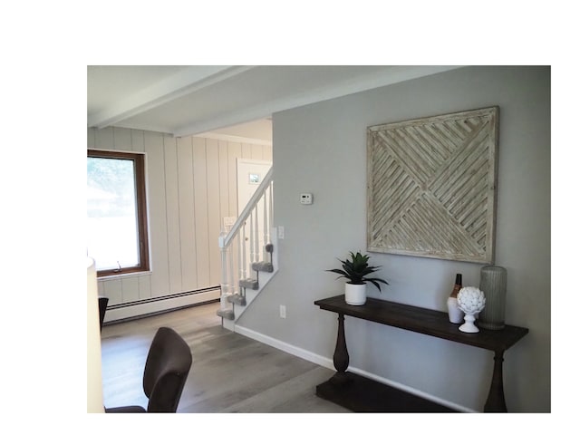 stairway featuring wood walls, beamed ceiling, a baseboard radiator, and hardwood / wood-style flooring