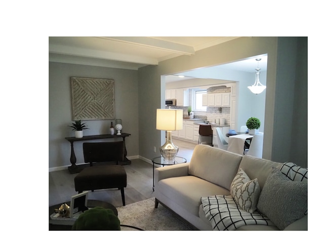 living room featuring beamed ceiling and light hardwood / wood-style floors