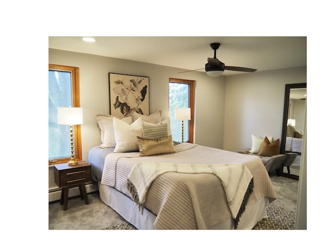 bedroom featuring baseboard heating, light carpet, and ceiling fan