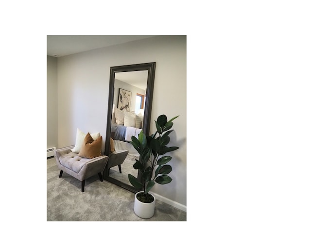 living area with light carpet and a baseboard heating unit