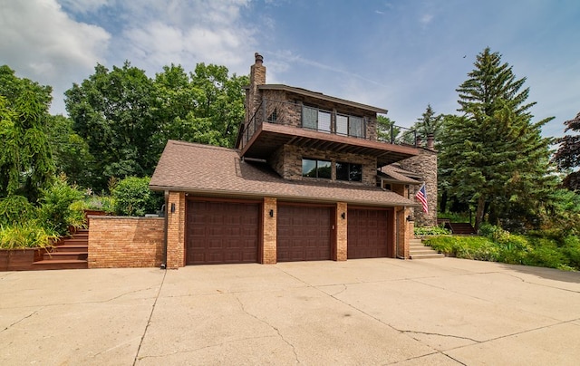 exterior space featuring a garage and a balcony