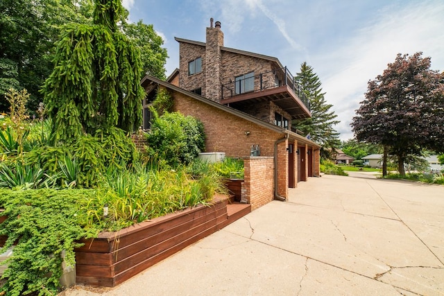 view of side of property with a balcony and a garage