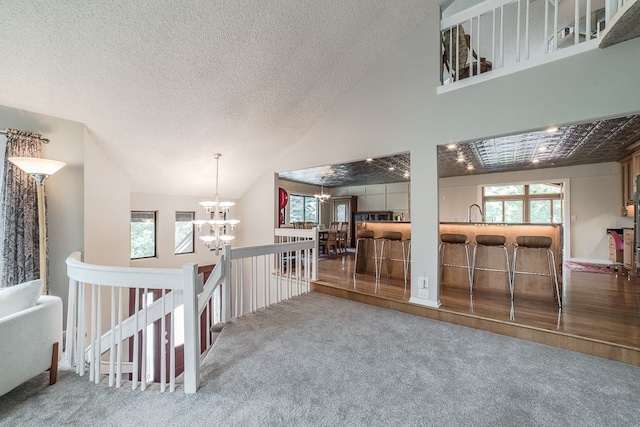 interior space featuring carpet flooring, a chandelier, and lofted ceiling