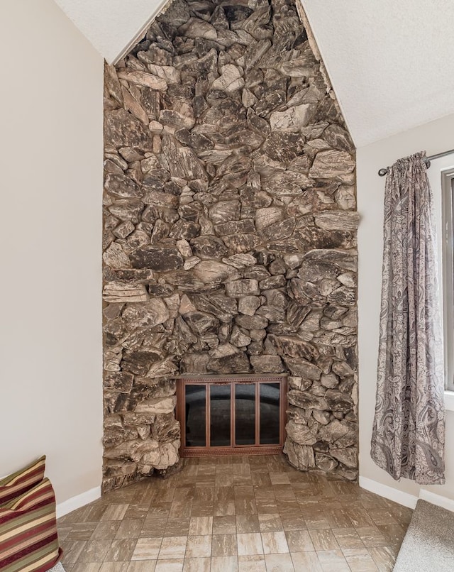 details featuring a stone fireplace and a textured ceiling