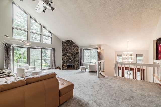 carpeted living room featuring high vaulted ceiling, a textured ceiling, and a notable chandelier