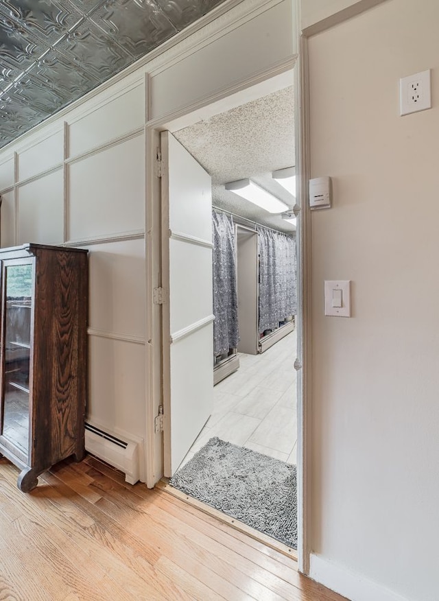 corridor with a baseboard radiator and light wood-type flooring