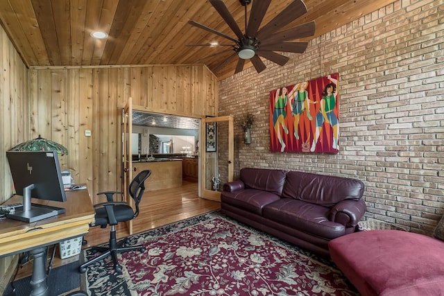 office space featuring brick wall, vaulted ceiling, ceiling fan, wood-type flooring, and wooden ceiling