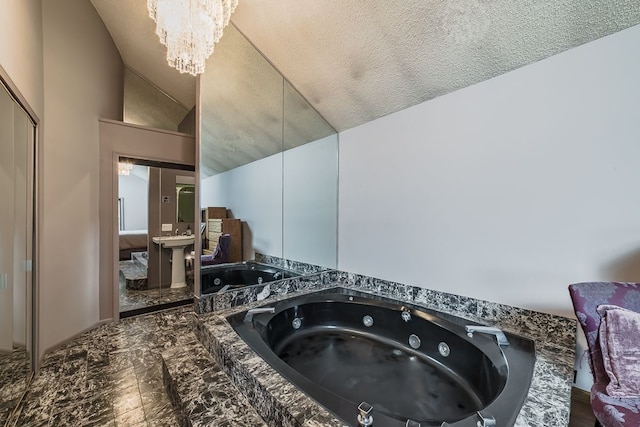 details with a chandelier, a textured ceiling, and a relaxing tiled tub