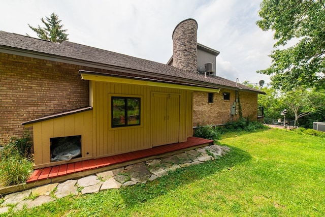 back of property with a lawn and cooling unit