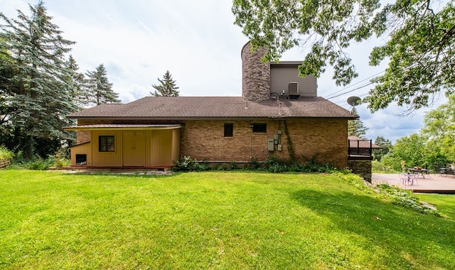 rear view of house with a lawn and cooling unit