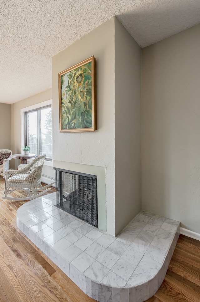 room details with hardwood / wood-style flooring, a fireplace, and a textured ceiling