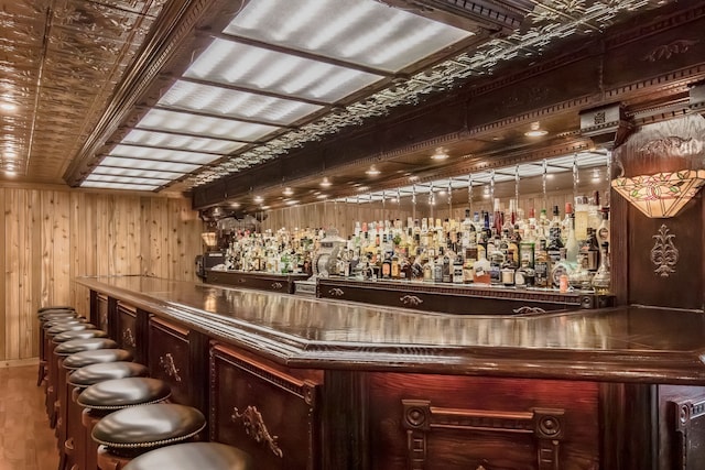 bar with hardwood / wood-style floors and wood walls