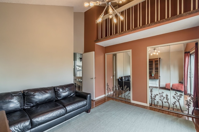 living room featuring hardwood / wood-style floors, high vaulted ceiling, and an inviting chandelier