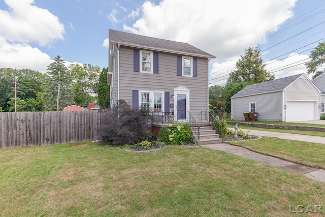 view of front of house with a front yard, a garage, and an outdoor structure