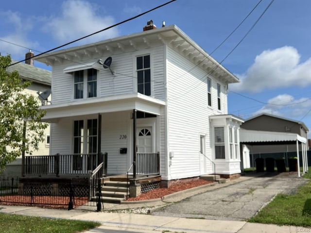 italianate home with covered porch and a carport