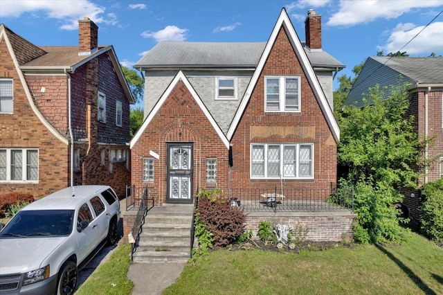 tudor house featuring a front lawn