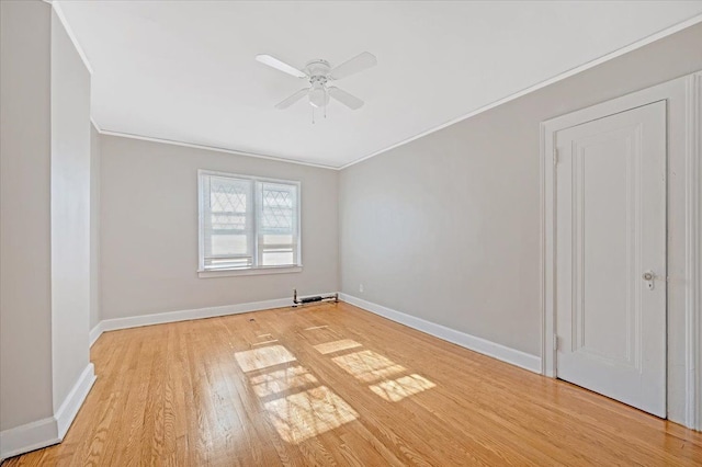 empty room with ceiling fan, ornamental molding, and light hardwood / wood-style flooring