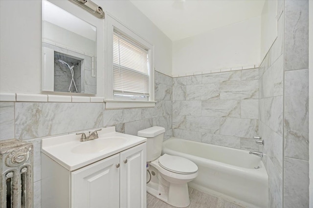 full bathroom with vanity, tiled shower / bath combo, tile walls, and toilet