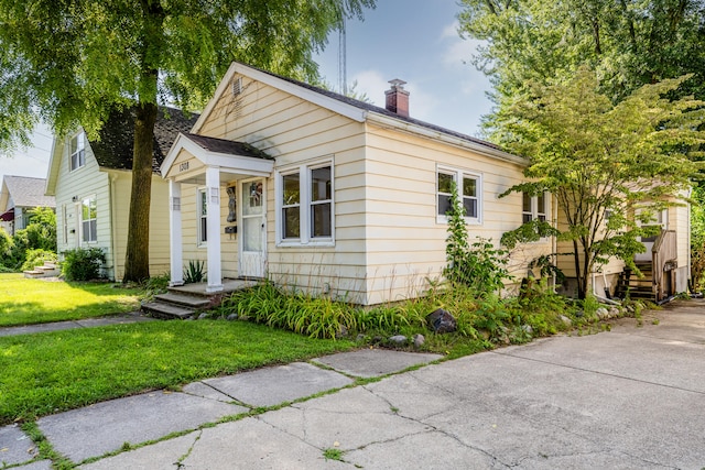 bungalow-style home with a front yard