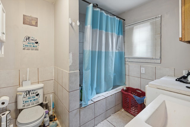 full bathroom with sink, tile patterned flooring, toilet, shower / bath combo with shower curtain, and tile walls