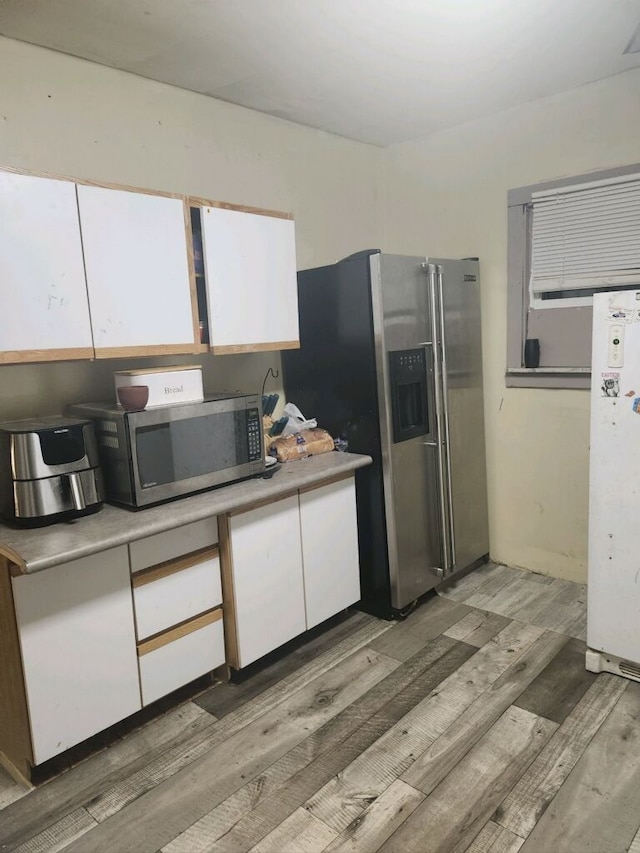 kitchen with white cabinets, dark hardwood / wood-style flooring, and appliances with stainless steel finishes