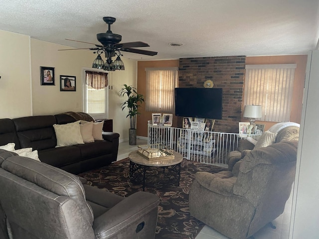 living room with tile patterned floors, ceiling fan, and a textured ceiling