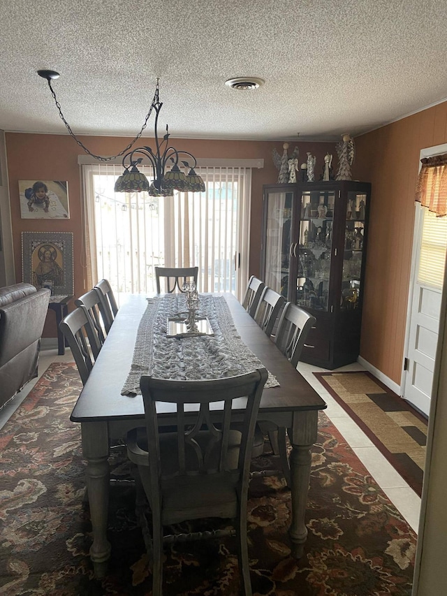 dining area featuring a textured ceiling and a notable chandelier